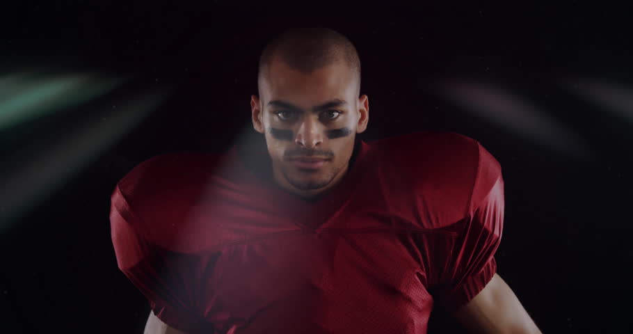 Preparing for game, football player in red jersey showing intense focus. Sports, athlete, concentration, determination, training, competitive