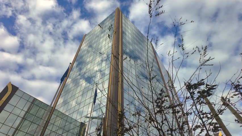 Glass facade of OLAF headquarters building in Brussels under cloudy sky