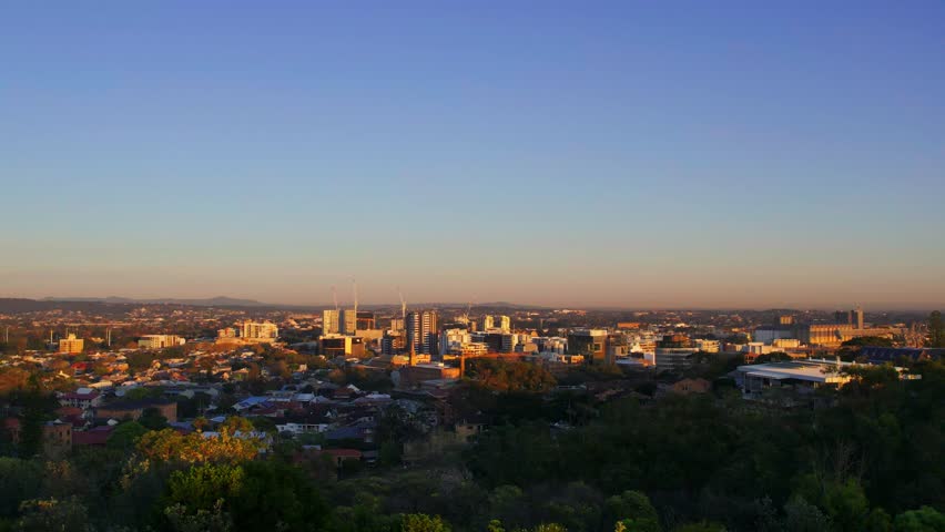 Sunrise light washes over Newcastle city skyline and landscape in peaceful morning scene, establishing static backdrop