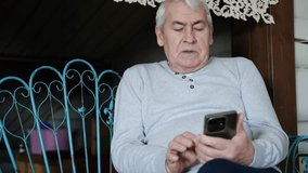 Portrait of senior man using mobile phone, holding device, texting, surfing internet. Old male looking at web camera, talking online. Elderly person chatting. Modern technologies and older generation - Powered by Shutterstock - Get 15% off with code: PIKWIZARD15