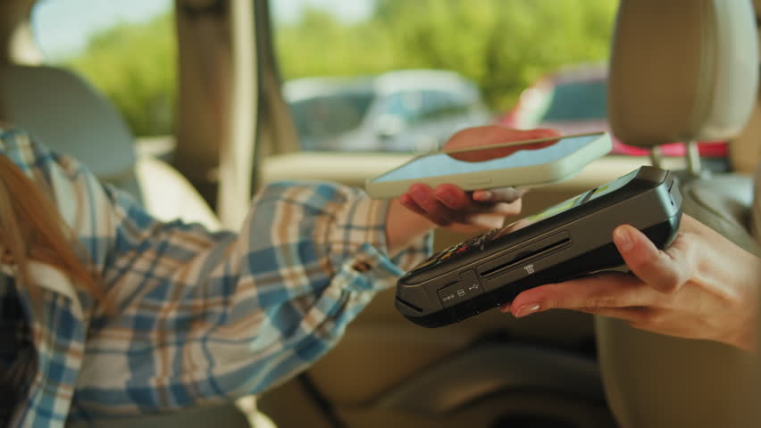 Payment in taxi, Businesswoman In Back Of Taxi Paying Fare Using Contactless Payment App On Mobile Phone