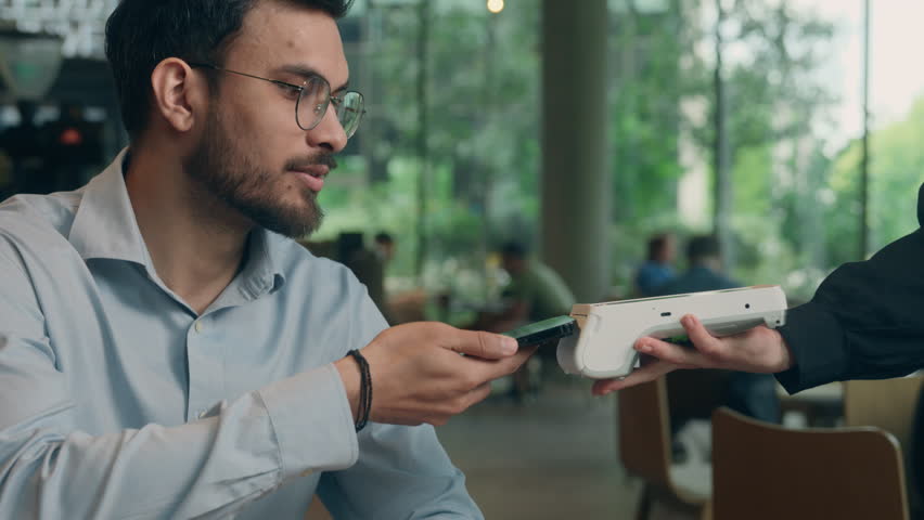 Indian business man guy male businessman visitor customer contactless NFC payment mobile phone buy purchase cafe order cashless service online bank wifi scan credit card smartphone terminal pay waiter