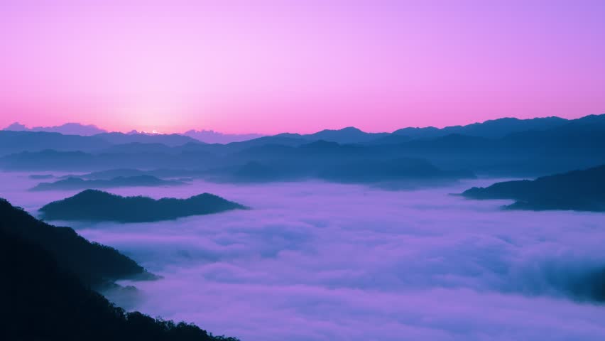 Behold the enchanting dawn as sunlight graces the misty mountains of Xindian, Taiwan. The sea of clouds dances in harmony with the awakening sky, revealing nature