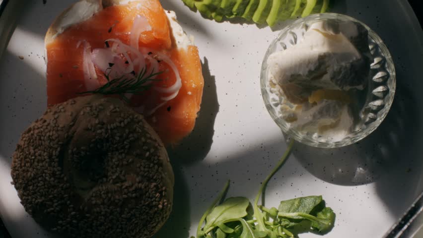 Bagel sandwich brunch, lunch plate of a bagel with smoked salmon and cream cheese and ham, close up morning cafe menu.