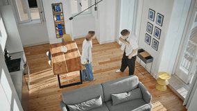 Happy spouses buying house together. Top view excited man giving apartment key spinning girlfriend in sunny room. Energetic woman jumping hugging boyfriend. Love couple celebrating home relocation. - Powered by Shutterstock - Get 15% off with code: PIKWIZARD15