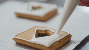 Close-up of icing process on cookie placed on textured paper, with another decorated cookie in the background, as white frosting is piped around a green filling - Powered by Shutterstock - Get 15% off with code: PIKWIZARD15