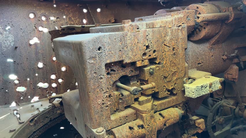 Rusted old machine with holes in it. The holes are from bullets