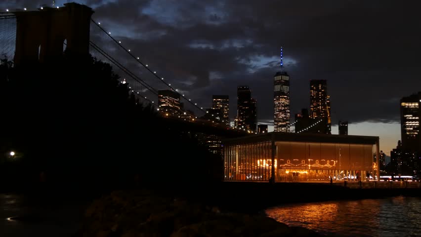 Brooklyn Bridge, New York City Manhattan downtown skyline cityscape, United States. Waterfront Pebble Beach, carousel in Dumbo, USA. Dramatic twilight dusk. Evening or night sky. World Trade Center.
