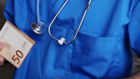 patient giving bribery to doctor. hand putting in pocket some money or putting on the table. corruption problem in medical system, stethoscope close up, medical assistant looking on bancnote. - Powered by Shutterstock - Get 15% off with code: PIKWIZARD15