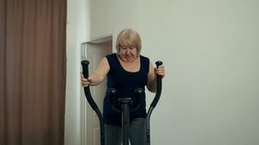 Senior woman working out on elliptical trainer at home - Powered by Shutterstock - Get 15% off with code: PIKWIZARD15