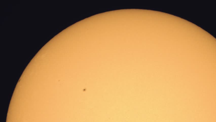 Surface of the Sun through telescope with visible sunspots and surface texture and atmosphere turbulences