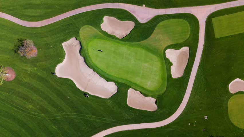 Top Down Aerial View of Golf Course Green with Sand Traps and Golfers in Action