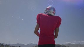 Football player pointing with digital data processing animation over clear sky. Sports, athlete, technology, motion, analytics, innovation - Powered by Shutterstock - Get 15% off with code: PIKWIZARD15