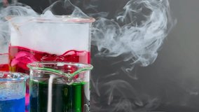 A mesmerizing display of colorful liquids and swirling smoke in laboratory beakers. - Powered by Shutterstock - Get 15% off with code: PIKWIZARD15