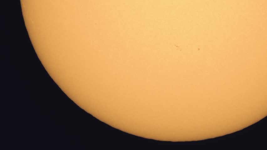 Surface of the Sun through telescope with visible sunspots and surface texture and atmosphere turbulences