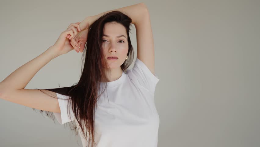 Beautiful young brunette woman with white tshirt at studio. Beautiful woman having smooth healthy skin. Skincare treatment, cosmetics and anti age plastic surgery. Face lifting, cosmetics.