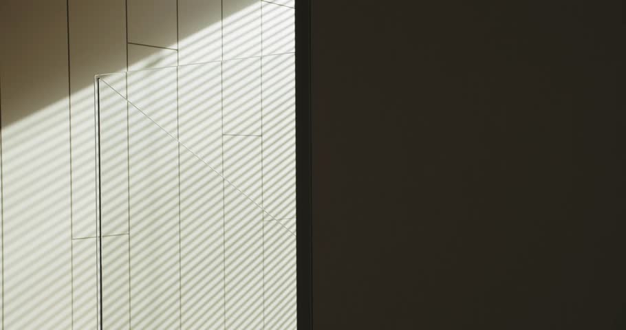 A minimalist interior featuring sharp lines and alternating patterns of light and shadow, showcasing modern architectural details and natural lighting. Minimalist Interior Design with Sunlight 