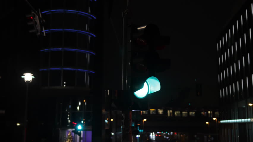 Go signal, Traffic signals, City lights. Close-up green traffic light night with modern buildings illuminated in background captures essence Berlin.