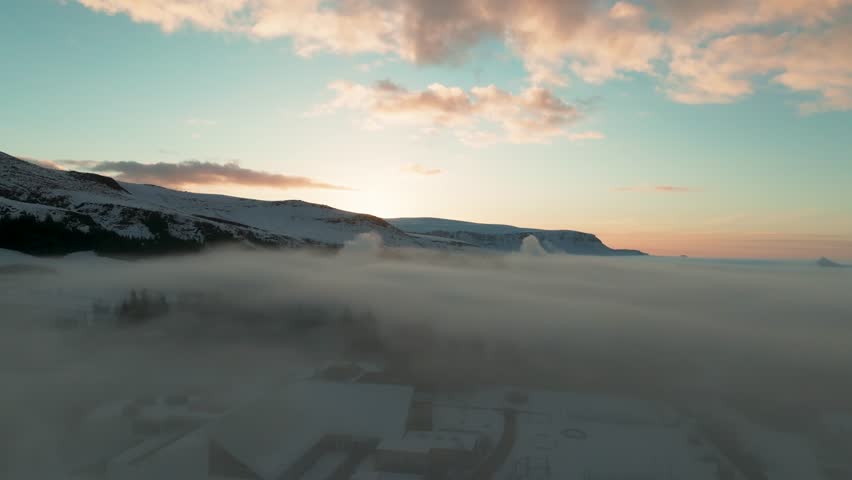 Flying Above Thick Fog Clouds Over Hveragerdi Town At Sunrise In South Iceland. drone shot