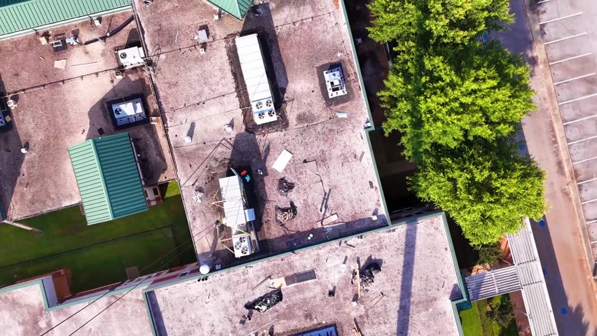 Aerial Rotate Down Pan Up The Building Complex Under Construction, With Exposed Concrete, A Crane, And The Skyline In The Background Under Cloudy Blue Skies - South Carolina - HD stock video