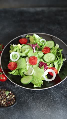 Vegetable salad tomato, cucumber, lettuce, green leaf lettuce, onion appetizer vegetable dish fresh gourmet food background rustic food top view copy space keto and paleo diet vegetarian vegan food