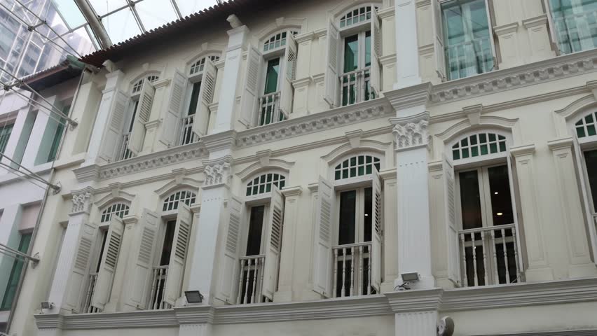 Front view of traditional vintage Singapore shop house exterior with arched windows and open antique wooden