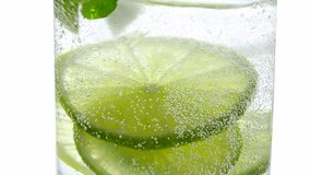 Refreshing non-alcoholic drink with lime slices and mint leaves in sparkling water - Powered by Shutterstock - Get 15% off with code: PIKWIZARD15