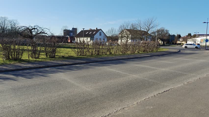 A large tractor with plows is driving on the road