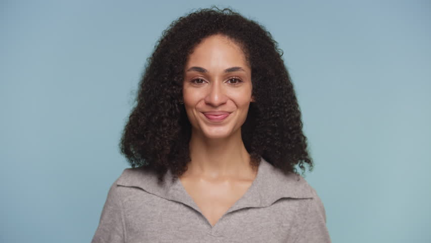 Playful Woman Smirking Against Blue Background
