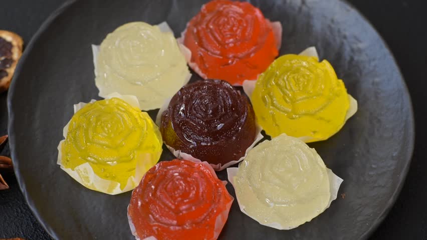 Jelly candies or homemade marmalade with different flavors on a dark concrete background