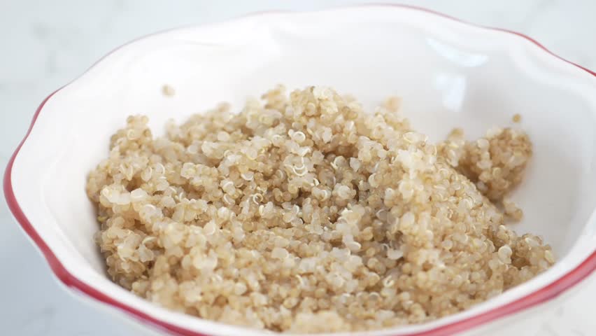 spoon pick healthy quinoa from a bowl 