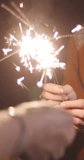 Vertical Screen : Young asia couple having fun and celebrates with sparklers lights in camping on beach at night. Male female traveler relax at campsite. Outdoor activity, adventure travel vacation. - Powered by Shutterstock - Get 15% off with code: PIKWIZARD15