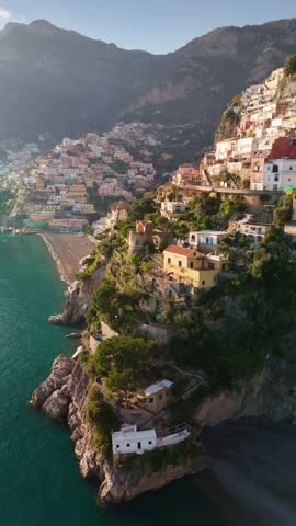 Epic vertical shot of colorful village Positano, Amalfi coast, Italy. Fly over colorful houses, church and beach in Positano at sunset