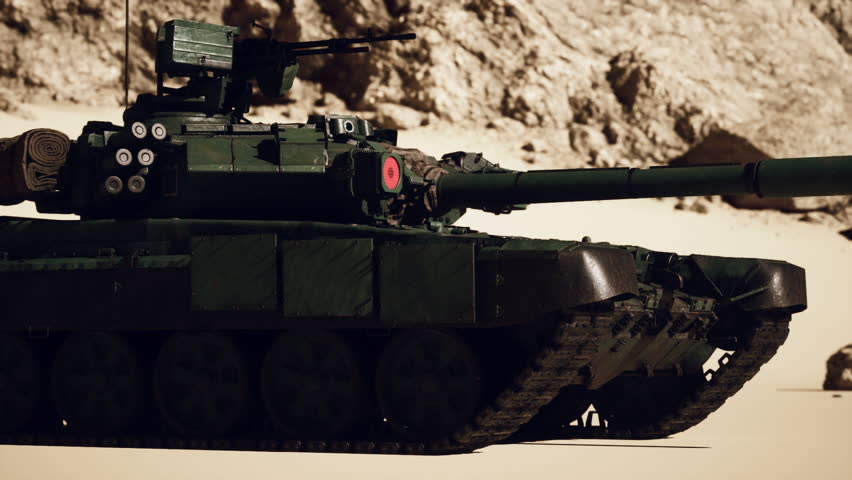 A military tank drives through the sandy desert landscape.