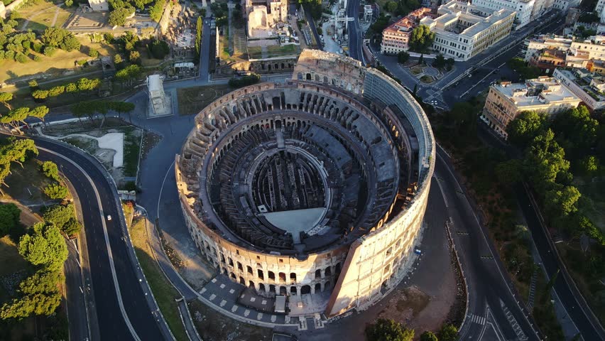 Majestic top-down sunrise shot of Rome's Colosseum, deserted city streets, Italy