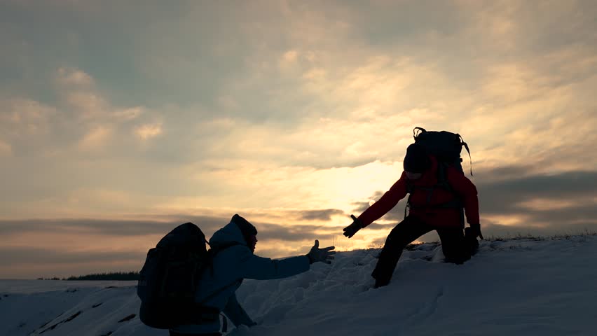 Go towards your goal. Travelers climb one after another on rock Climbers silhouettes stretch their hands to each other climbing to top of hill. Teamwork of business people. Team of businessmen victory