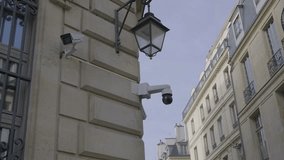 Surveillance cameras on the corner of a building in Paris with a clear blue sky - Powered by Shutterstock - Get 15% off with code: PIKWIZARD15