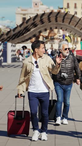 Man tourist running late for transport trip together with senior parents - Group of travel family friends having fun going to airport