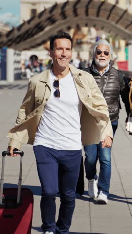 Man tourist running late for transport trip together with senior parents - Group of travel family friends having fun going to airport