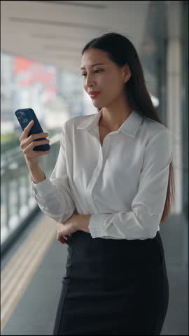 Vertical Video. Excited Charming Lady Using Telephone And Looking At Screen with Yes Gesture. Cute Attractive Business Woman Celebrates Good News Reading from The Smartphone. People And Victory