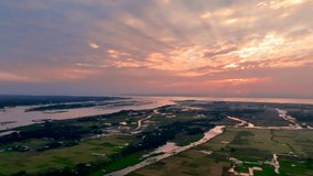 breathtaking sunset over a vast rural landscape, with winding rivers, lush green fields, and scattered villages, creating a serene Aerial view of nature’s beauty - Powered by Shutterstock - Get 15% off with code: PIKWIZARD15