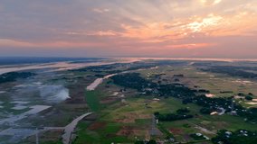 breathtaking sunset over a vast rural landscape, with winding rivers, lush green fields, and scattered villages, creating a serene and picturesque view of nature’s beauty - Powered by Shutterstock - Get 15% off with code: PIKWIZARD15
