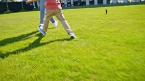 Active parent kid playing soccer in park on grass closeup. Happy carefree family father and son enjoying football together. Dad and boy running with ball outdoor. Sport and healthy lifestyle concept  - Powered by Shutterstock - Get 15% off with code: PIKWIZARD15