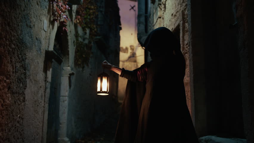 Cloaked Man Holding The Lantern Through a Veil of Night