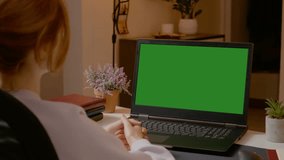 Woman engages in a video call from her home office, using a laptop with a green screen to facilitate seamless digital communication and conversation. - Powered by Shutterstock - Get 15% off with code: PIKWIZARD15