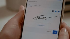 Woman is using her smartphone to create a digital signature. She carefully gestures with her finger on the screen while focused on the task. - Powered by Shutterstock - Get 15% off with code: PIKWIZARD15