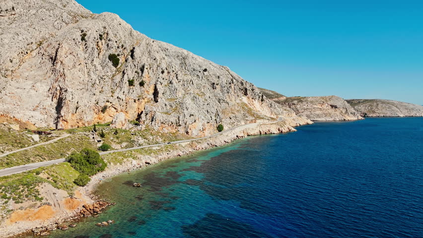 Car moving by sea curved road near a tranquilly sea on the Greek coast. Aerial view