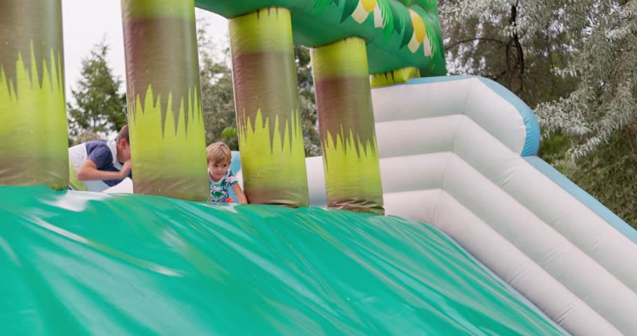 Kids Playing on Inflatable Slide Outdoors