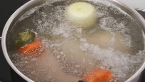 Foamy meat broth with onion, carrot and bay leaf boiling in large pot during cooking process, fat spots floating on surface - Powered by Shutterstock - Get 15% off with code: PIKWIZARD15
