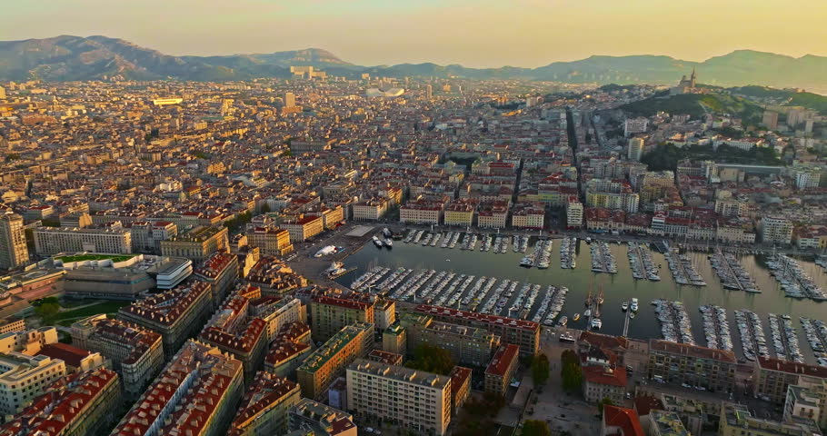 Many boats and yachts are parked in the city marina. Aerial view of the port of Marseille in the morning sun. Drone view of Marseille in the south of France